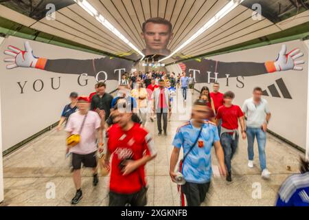 Fußballfans auf dem Heimweg nach dem Halbfinale, eilen vorbei am überdimensionalen Manuel Neuer im U-Bahnhof Odeonsplatz, Fußball-EM, München, 9. Juillet 2024 Deutschland, München, 9. Juli 2024, Fußballfans auf dem Heimweg vom Halbfinal Spanien-Frankreich, Spanien gewinnt mit 2:1 und ist damit im finale, spanische Fußballfans in Rot eilen vorbei am überdimensionalen Manuel Neuer im U-Bahnhof Odeonsplatz, Dekoration zur Fußball-EM im Verbindungnel zwischen den beiden U-Bahn-Linien, UEFA EURO 2024, Fußball-Europameisterschaft, Fußball, Sport *** fans de football sur le chemin de la maison après le semi-fi Banque D'Images