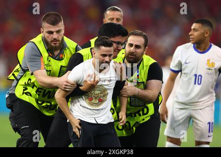 Munich, Allemagne. 09 juillet 2024. Un envahisseur de terrain est retiré du terrain par les commissaires de la sécurité lors de la demi-finale de l'UEFA Euro 2024 au Munich Football Arena, en Allemagne, le 9 juillet 2024. Chris Brunskill/UPI crédit : UPI/Alamy Live News Banque D'Images