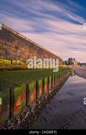 Le mur et les défenses maritimes en face du Scarborough Spa reflètent la lumière du soleil tôt le matin. Banque D'Images