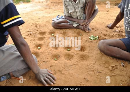 Enfants jouant à Nxtuva, Licaca, Inhambane, Mozambique. Nxtuva est membre de Mancala, une famille de jeux de stratégie à deux joueurs au tour par tour. Banque D'Images