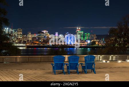 Vieux-Port de Montréal et horizon du centre-ville la nuit. Les lumières colorées des bâtiments se reflètent dans l'eau. Montréal, Québec, Canada. Banque D'Images
