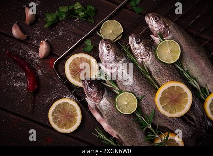 Truite arc-en-ciel crue, avec du citron et des herbes, sur une table en bois, pas de gens Banque D'Images