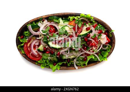 Salade de légumes frais, concombres, tomates, oignons rouges, avec noix et graines de grenade, vue de dessus, dans une assiette d'argile, isolé Banque D'Images