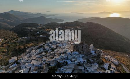 Vue aérienne de Chora à Amorgos, Grèce avec des maisons blanches et un coucher de soleil sur la mer Égée. Banque D'Images