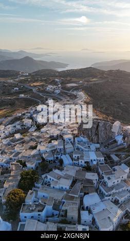 Vue aérienne du village pittoresque de Chora à Amorgos, en Grèce, avec des maisons blanchies à la chaux et des rues sinueuses au coucher du soleil. Banque D'Images