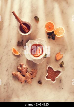Thé au gingembre, au citron, à la menthe et au miel, sur une table en marbre, vue de dessus, lumière du soleil, pas de personnes, mise au point sélective Banque D'Images