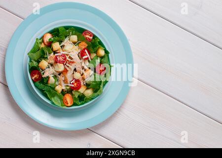 Salade César classique, avec cerise et croûtons, vue de dessus, sur une table blanche, horizontale, sans personne Banque D'Images