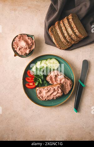 Pâté de viande de foie étalé sur pain de seigle, petit déjeuner, gros plan, fond beige. pas de gens, focalisation sélective Banque D'Images