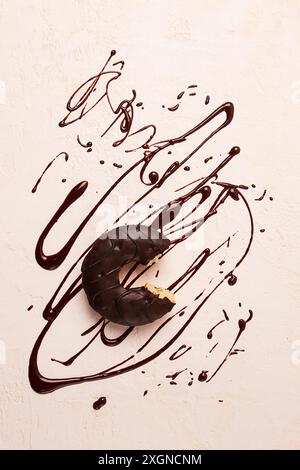 Beignets, en glaçage au chocolat, sur fond beige, avec chocolat liquide Banque D'Images
