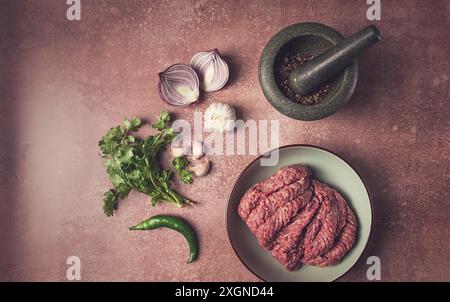 Viande hachée fraîche, crue, avec épices et ingrédients. sur la table, préparation, vue de dessus Banque D'Images