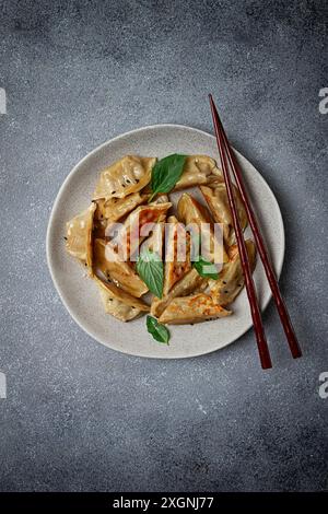 Boulettes de gyoza japonaises frites, avec porc, graines de sésame, oignons verts Banque D'Images