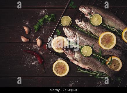 Truite arc-en-ciel crue, avec du citron et des herbes, sur une table en bois, pas de gens Banque D'Images