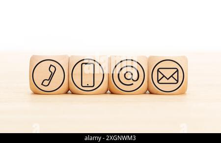 Contactez-nous icônes dans des blocs de bois sur le bureau en bois. Copier l'espace. Arrière-plan blanc Banque D'Images
