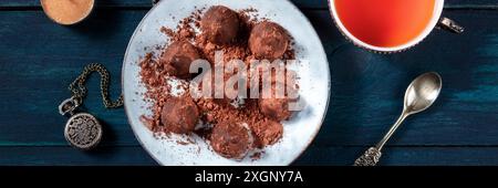 Truffes au chocolat et panorama sur le thé sur un bois bleu foncé arrière-plan Banque D'Images