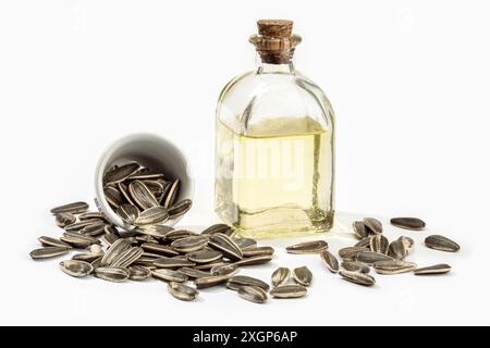 Huile de tournesol en bouteille de verre et graines isolées sur fond blanc. Huile de cuisson Banque D'Images