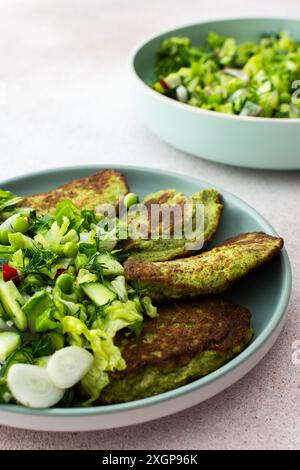 Crêpes aux courgettes et au brocoli servies avec une salade mixte de concombres, jeunes pois et radis. Ce plat végétarien sain est à la fois délicieux et nu Banque D'Images