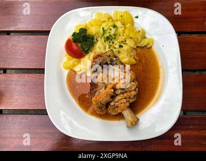 Demi-jarret de porc, frits croustillants, salade de pommes de terre, tomate, ciboulette, persil, assiette, nourriture, Stuttgart, Bade-Wuerttemberg, Allemagne Banque D'Images