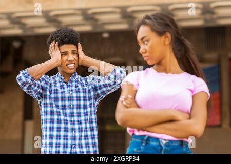 Adolescent couvrant les oreilles pendant la dispute avec fille Banque D'Images