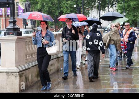 Londres, Royaume-Uni. 09 juillet 2023. Les touristes s'abritent sous des parapluies dans le centre de Londres par un jour de pluie dans la capitale. Les dernières données du met Office montrent que Londres a enregistré 86 % de ses précipitations moyennes de juillet au cours des huit premiers jours du mois, car un avertissement météorologique jaune a été prolongé pour de nombreuses régions du Royaume-Uni. Crédit : SOPA images Limited/Alamy Live News Banque D'Images