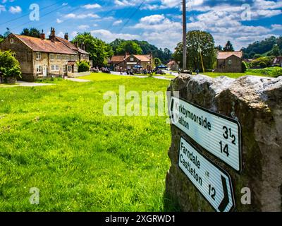 Hutton le Hole, Yorkshire du Nord, Angleterre. regardant rose et crown pub avec des panneaux indiquant les villes voisines Banque D'Images