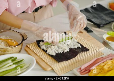 Femme fabriquant le Kimbap coréen dans la cuisine Banque D'Images