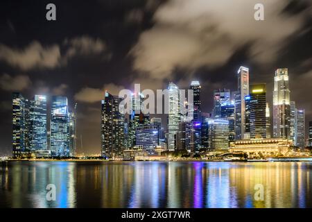 Superbe vue nocturne du centre-ville de Singapour. Gratte-ciel étonnants et autres bâtiments modernes sur fond de ciel sombre. Banque D'Images