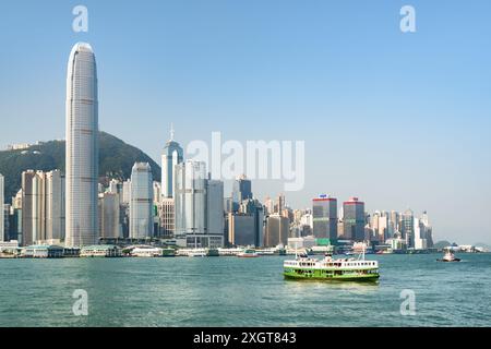 Magnifique vue sur l'horizon de l'île de Hong Kong par jour ensoleillé. Ferry traversant Victoria Harbor. Les gratte-ciel du centre-ville sont visibles du côté de Kowloon. Banque D'Images