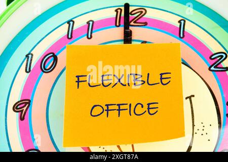 Symbole de bureau flexible. Concept words bureau flexible sur un autocollant jaune sur le fond d'un cadran d'horloge avec des mains Banque D'Images