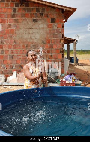 Rodelas, bahia, brésil - 15 juin 2024 : une femme recueille l'eau d'un réservoir d'eau dans la zone rurale de la ville de ​​the, Rodelas. Banque D'Images