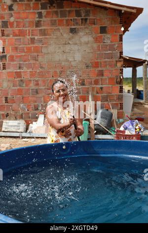 Rodelas, bahia, brésil - 15 juin 2024 : une femme recueille l'eau d'un réservoir d'eau dans la zone rurale de la ville de ​​the, Rodelas. Banque D'Images