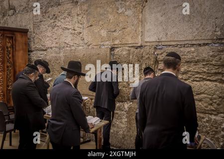 Plusieurs juifs ultra-orthodoxes (haredi) lisent la Torah devant le mur occidental (mur des lamentations) à Jérusalem, en Israël. Banque D'Images