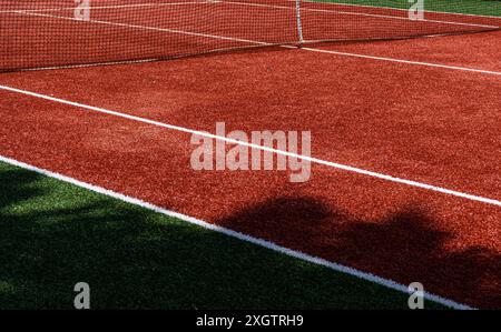 Image haute résolution capturant une vue détaillée d'un court de tennis rouge et vert éclatant. L’accent est mis sur la texture du terrain, la ligne blanche soignée Banque D'Images