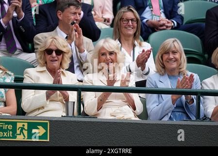 Queen Camilla (au centre), Annabel Elliot (à gauche) et Debbie Jevans, présidente du All England Lawn Tennis Club, participent à une vague à court One le dixième jour des Championnats de Wimbledon 2024 au All England Lawn Tennis and Croquet Club, Londres. Date de la photo : mercredi 10 juillet 2024. Banque D'Images