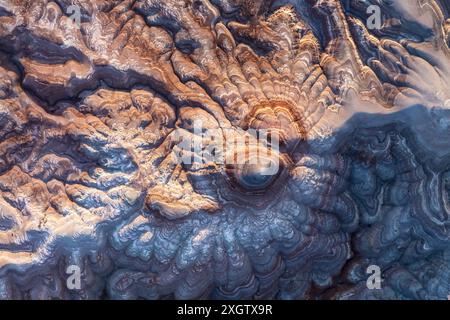 Superbe image aérienne mettant en valeur les motifs complexes et colorés et les couches d'argile bentonite dans un paysage désertique. Ces formations géologiques revivent Banque D'Images