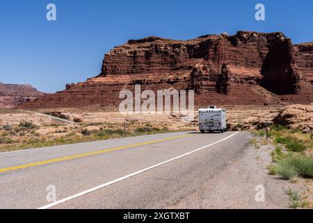 Un VR voyage sur une autoroute à travers White Canyon accidenté dans la zone de loisirs nationale de Glen Canyon, Utah, contre un ciel bleu clair. Banque D'Images