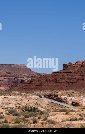 Un VR voyage sur une autoroute à travers White Canyon accidenté dans la zone de loisirs nationale de Glen Canyon, Utah, contre un ciel bleu clair. Banque D'Images