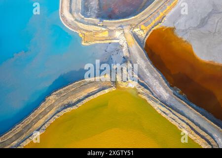 Un plan aérien abstrait capture les eaux toxiques mais saisissantes du fleuve Rio Tinto, reflétant ses couleurs uniques alors qu'il serpente à travers le paysage espagnol Banque D'Images