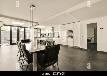 Cuisine moderne avec coin repas dans une maison Hilversumstraat, Amsterdam, avec des armoires blanches élégantes et de grandes fenêtres Banque D'Images