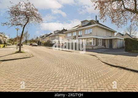 Un quartier résidentiel serein sur Jan Weilandlaan aux pays-Bas, avec une rangée de maisons modernes et une rue soigneusement pavée sous un ciel clair Banque D'Images