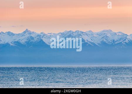 Lac Issyk-Koul, montagnes enneigées et ciel rose le matin. Kirghizistan Banque D'Images