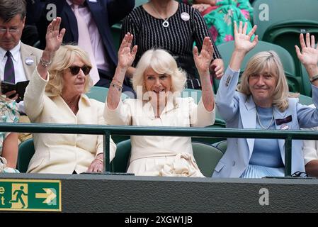 Queen Camilla (au centre), Annabel Elliot (à gauche) et Debbie Jevans, présidente du All England Lawn Tennis Club, participent à une vague à court One le dixième jour des Championnats de Wimbledon 2024 au All England Lawn Tennis and Croquet Club, Londres. Date de la photo : mercredi 10 juillet 2024. Banque D'Images