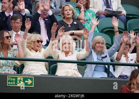 Queen Camilla (au centre), Annabel Elliot (à gauche) et Debbie Jevans, présidente du All England Lawn Tennis Club, participent à une vague à court One le dixième jour des Championnats de Wimbledon 2024 au All England Lawn Tennis and Croquet Club, Londres. Date de la photo : mercredi 10 juillet 2024. Banque D'Images