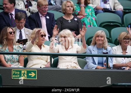 Queen Camilla (au centre), Annabel Elliot (à gauche) et Debbie Jevans, présidente du All England Lawn Tennis Club, participent à une vague à court One le dixième jour des Championnats de Wimbledon 2024 au All England Lawn Tennis and Croquet Club, Londres. Date de la photo : mercredi 10 juillet 2024. Banque D'Images