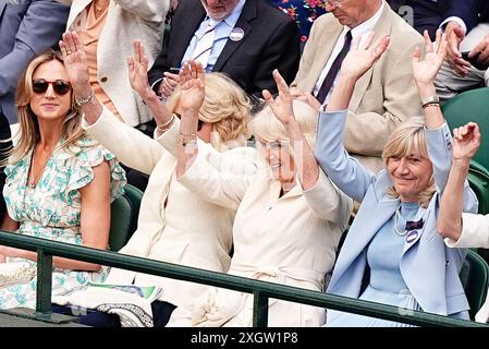 Queen Camilla (au centre), Annabel Elliot (à gauche) et Debbie Jevans, présidente du All England Lawn Tennis Club, participent à une vague à court One le dixième jour des Championnats de Wimbledon 2024 au All England Lawn Tennis and Croquet Club, Londres. Date de la photo : mercredi 10 juillet 2024. Banque D'Images