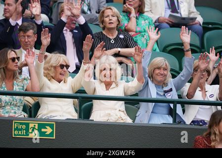 Queen Camilla (au centre), Annabel Elliot (à gauche) et Debbie Jevans, présidente du All England Lawn Tennis Club, participent à une vague à court One le dixième jour des Championnats de Wimbledon 2024 au All England Lawn Tennis and Croquet Club, Londres. Date de la photo : mercredi 10 juillet 2024. Banque D'Images