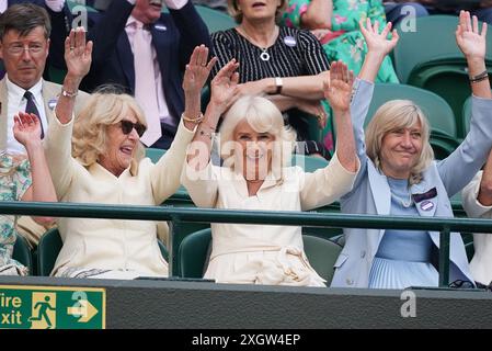 La reine Camilla (au centre), Annabel Elliot (à gauche) et Debbie Jevans, présidente du All England Lawn Tennis Club, participent à une vague le dixième jour des Championnats de Wimbledon 2024 au All England Lawn Tennis and Croquet Club, à Londres. Date de la photo : mercredi 10 juillet 2024. Banque D'Images