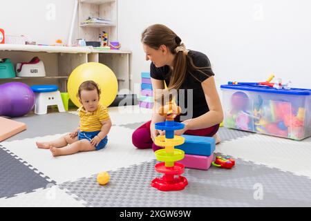 Un physiothérapeute travaille avec un jeune enfant dans une séance de thérapie. Banque D'Images