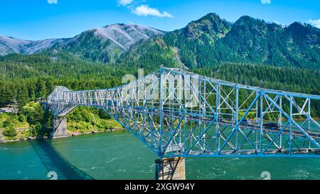 Vue aérienne du pont en treillis d'acier au-dessus de la rivière dans les montagnes boisées luxuriantes Banque D'Images