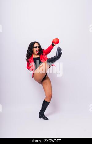 Femme africaine oversize avec des gants de boxe sur fond de studio, beau boxer féminin à la peau foncée Banque D'Images