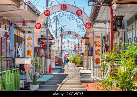 Penang, Malasia-avril 30 2023 : cette jetée de clan ornée, décorée avec des symboles chinois et bordée de boutiques et de restaurants, est construite sur pilotis, au bord de Banque D'Images